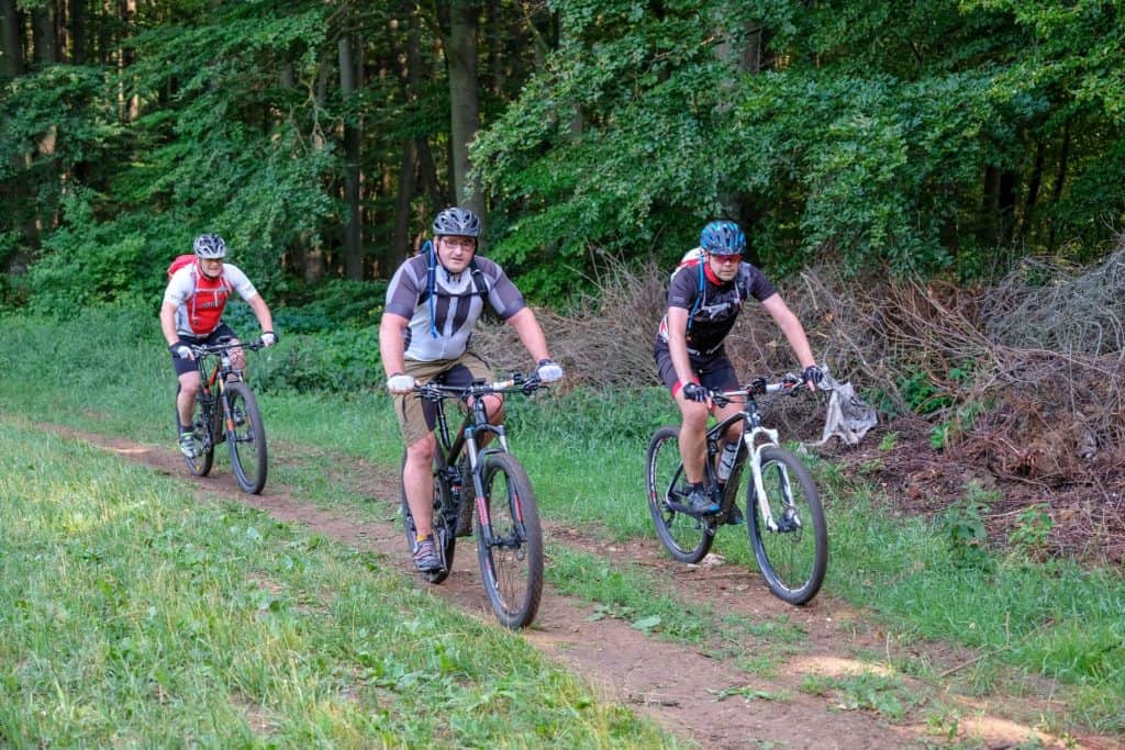 three-mountain-bikers riding with friends 