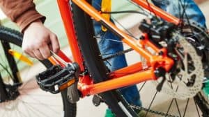 man checking the pedals and crank on a mtb