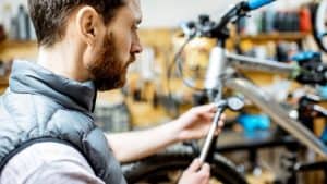 man using tool to inspect mountain bike