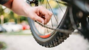 person checking mountain bike chain