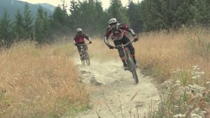 riders on a dusty mountain bike trail