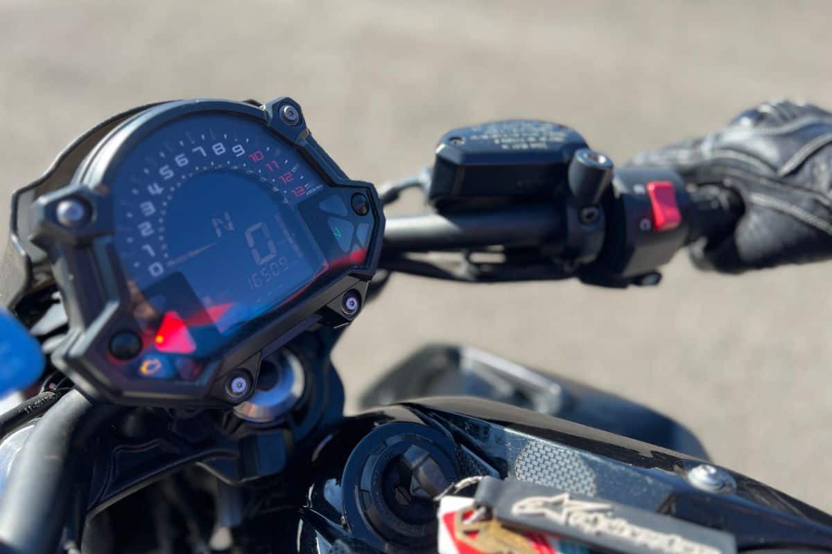 close up of motorcycle handlebars, controls gauge and speedometer