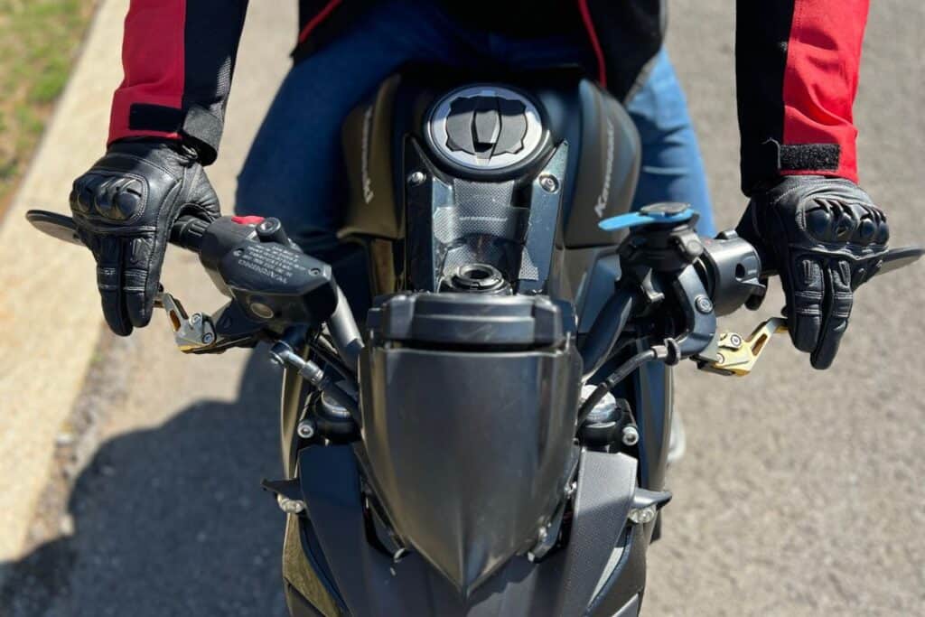 rider holding motorcycle handlebar and controls