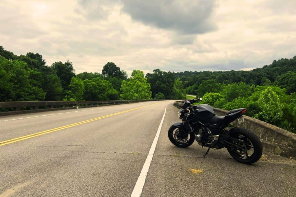 motorcycle on side on long scenic road