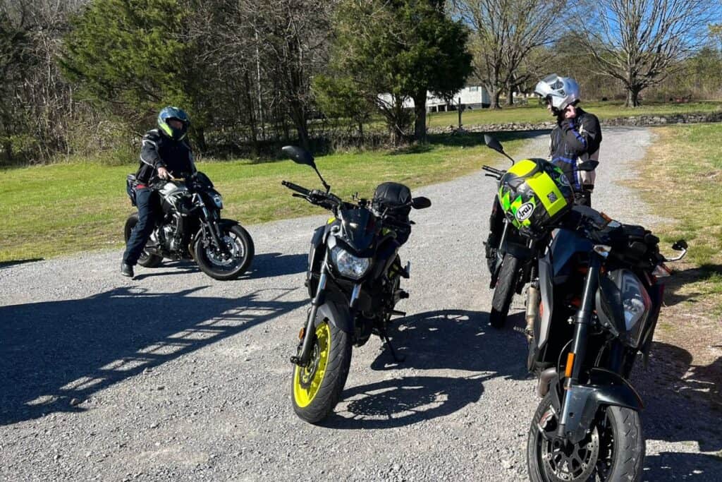 picture of group of bikers with one moving a motorcycle