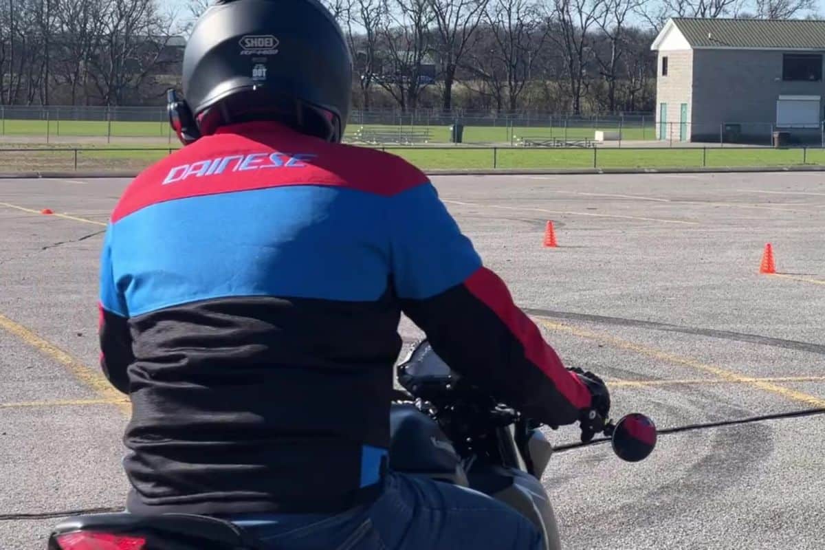 back view of rider with jacket and helmet on motorcycle course