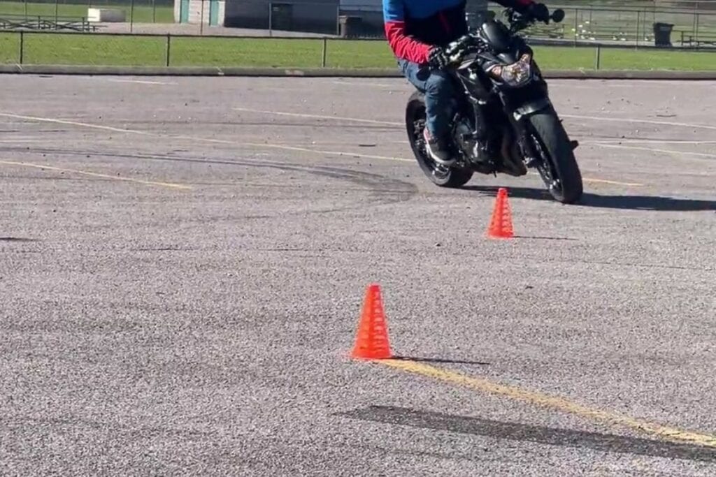 motorcycle and rider leaning into turn on motorcycle course