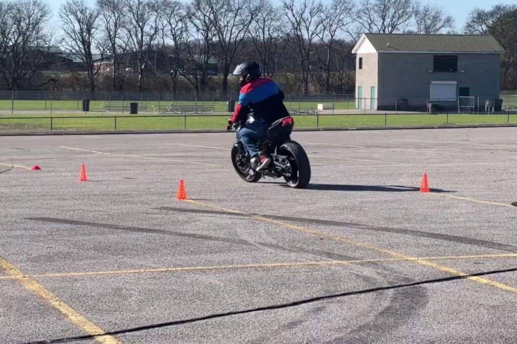 rider taking left around cones on motorcycle course