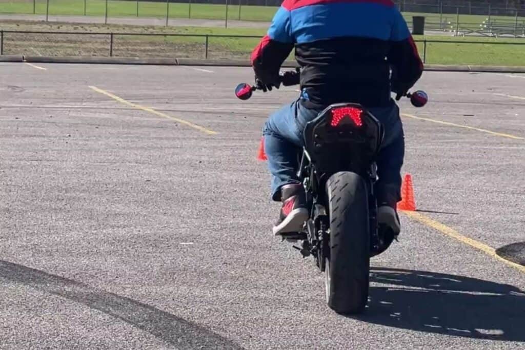 rearview of motorcycle rider on motorcycle course with view of motorcycle jacket, helmet and shoes